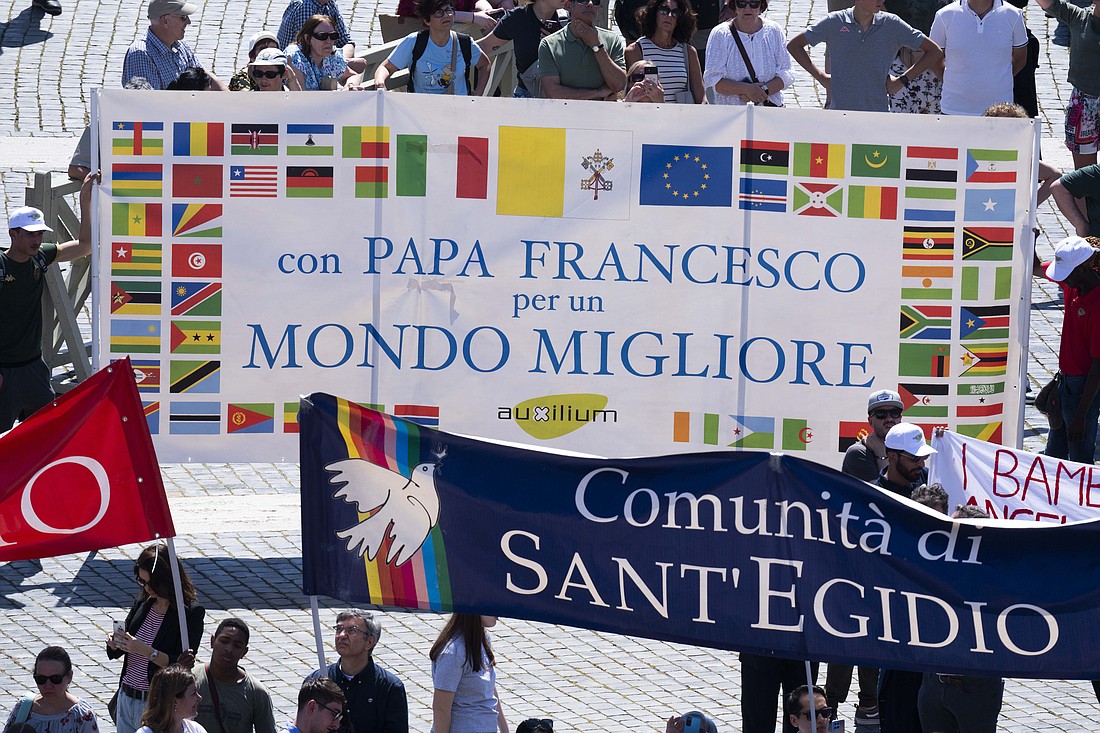 As Pope Francis pleaded with nations to exercise restraint and avoid an escalation of violence in the Middle East after his recitation of the "Regina Coeli" prayer at the Vatican April 14, 2024, members of the Auxilium Cooperative, a social-service agency, hold up a sign that says, in Italian: "With Pope Francis for a Better World." (CNS photo/Vatican Media)