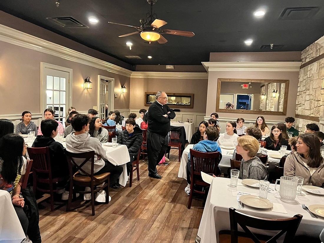 Msgr. Gervasio fields questions from the Confirmation candidates in Our Lady of Sorrows-St. Anthony Parish, Hamilton, during a “Pizza With The Pastor” gathering. Courtesy photo