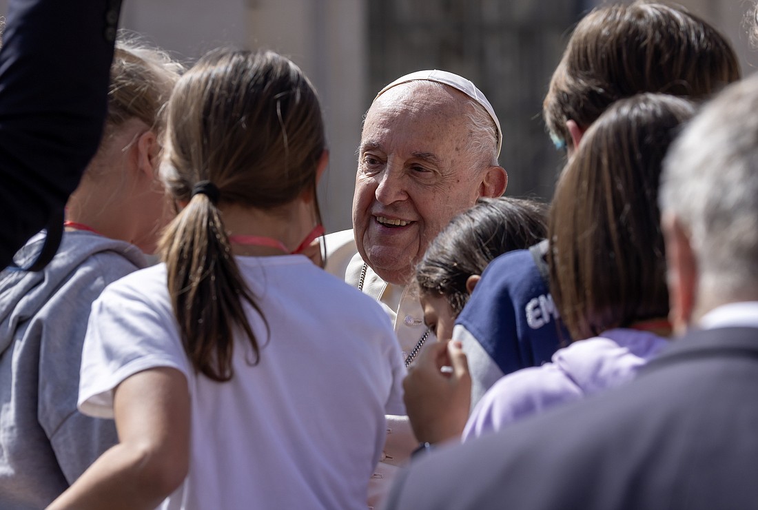 Pope Francis stops to talk with a group of children after his weekly general audience in St. Peter's Square at the Vatican April 17, 2024. CNS photo/Pablo Esparza
