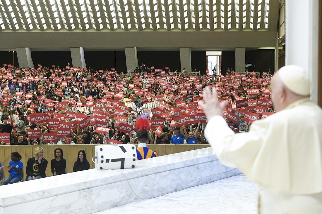 Pope Francis waves to about 6,000 Italian schoolchildren involved in the National Network of Schools of Peace, a civic education program, in the Paul VI Audience Hall at the Vatican April 19, 2024. (CNS photo/Vatican Media)