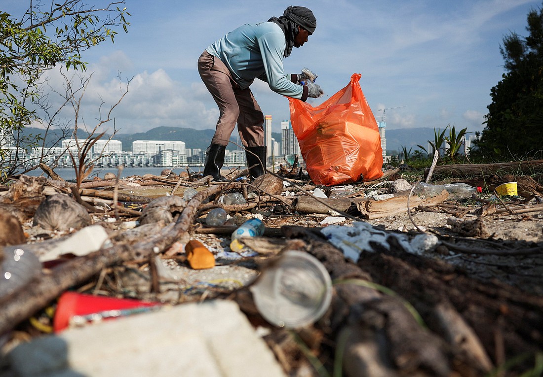 A volunteer collects rubbish during a beach clean-up campaign organized in conjunction with the Earth Day celebration in George Town, Malaysia,  April 22, 2024. Earth Day is an annual event on April 22 to demonstrate support for environmental protection. (OSV News photo/Hasnoor Hussain, Reuters)
