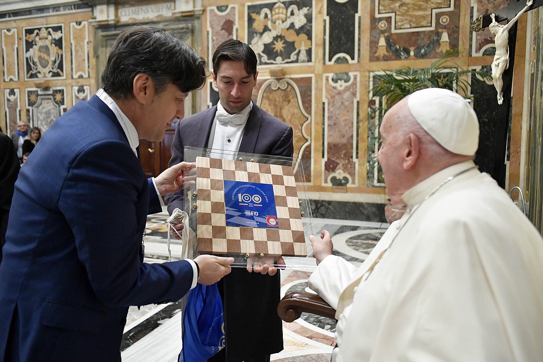 Pope Francis receives a wooden checkerboard from members of the Italian Checkers Federation during a meeting at the Vatican April 26, 2024. (CNS photo/Vatican Media)