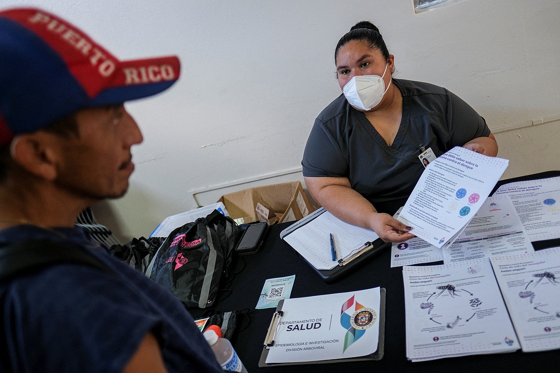 Monica Soto, a registered nurse, gives information to Francisco Sierra during a health fair  March 27, 2024, following a spike in dengue fever cases in San Juan, Puerto Rico. (OSV News photo/Ricardo Arduengo, Reuters)