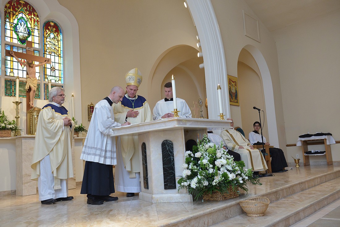 During a Mass in  St. Anthony of Padua Church, Red Bank, in May, 2016, Bishop O’Connell, then-Father Dennis Apoldite and Father Alberto Tamayo signed a canonical decree and Letters of Agreement establishing the relationship between the Oratory and the Diocese. Here the documents are being signed by Father Tamayo, who became the Oratory’s provost. Craig Pittelli photo