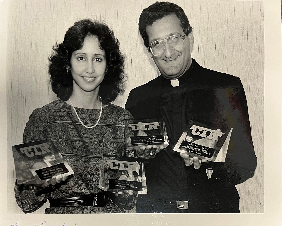 Marianne Hartman and Msgr. Leonard Troiano display multiple 1984 programming awards from Catholic Telecommunications Network of America. Courtesy photo