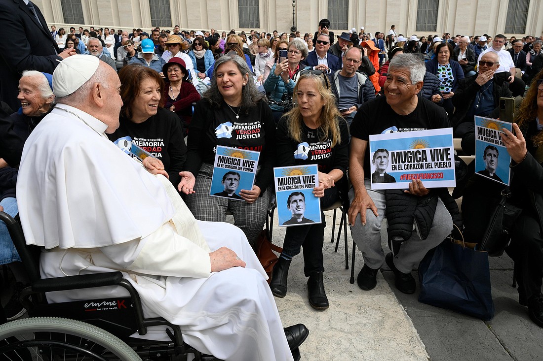 Pope Francis greets a group of Argentine visitors holding images of Father Carlos Mugica, an Argentine priest and activist, after the pope's general audience at the Vatican May 8, 2024. (CNS photo/Vatican Media)