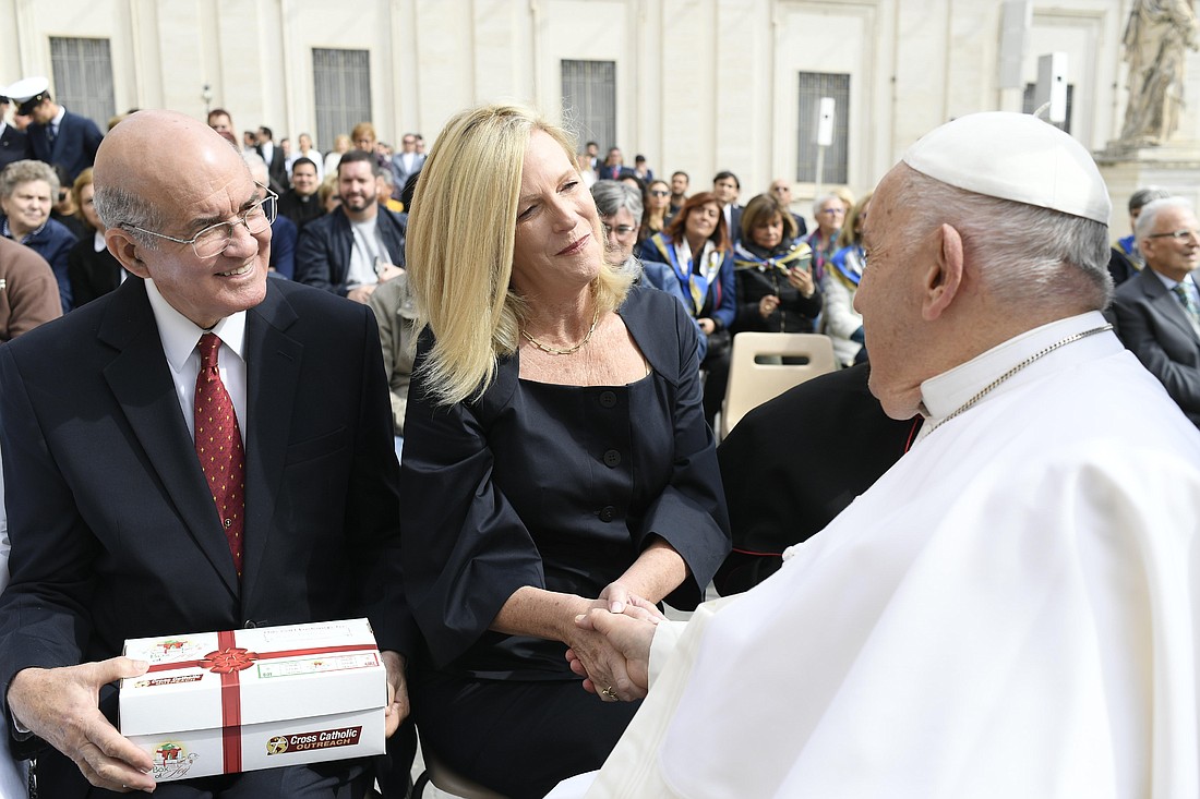 Pope Francis shakes hands with Michele Sagarino, president of Cross Catholic Outreach, as Jim Cavnar, the organization's co-founder and chief executive officer, looks on after the pope's general audience in St. Peter's Square at the Vatican May 8, 2024. (CNS photo/Vatican Media)