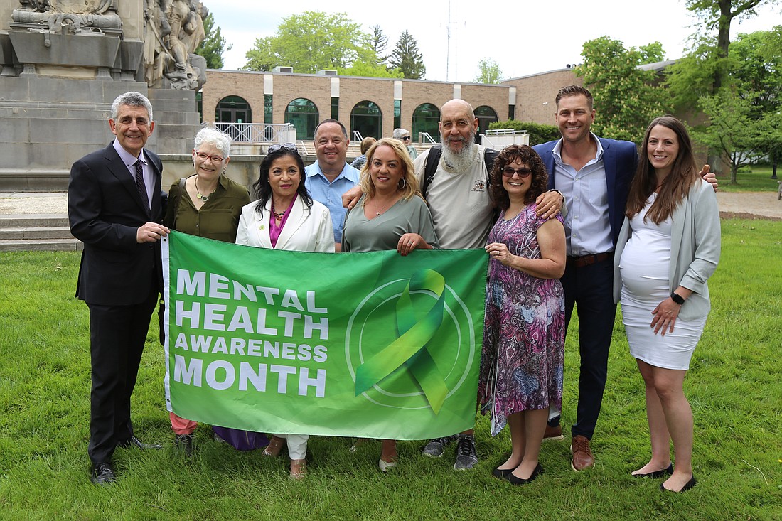 Representatives of Catholic Charities, Diocese of Trenton, pose with the Mental Health Awareness Month flag at the May 7 flag raising, along with other Princeton and Mercer County community leaders. Courtesy photo