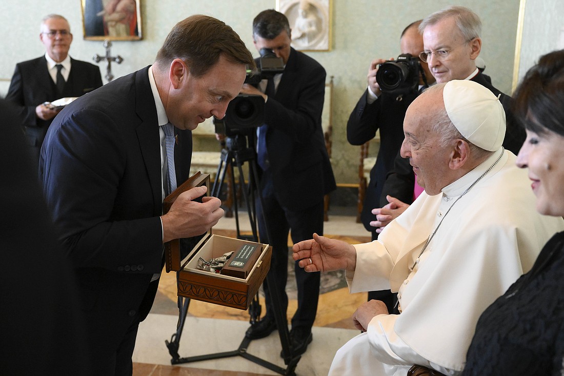 Mark C. Reed, president of Loyola University Chicago, presents Pope Francis with a small replica of the "Los Lobos de Loyola" statue designed by Mexican artist Pancho Cardenas during an audience with members of the board of trustees of the Jesuit university at the Vatican May 20, 2024. (CNS photo/Vatican Media)