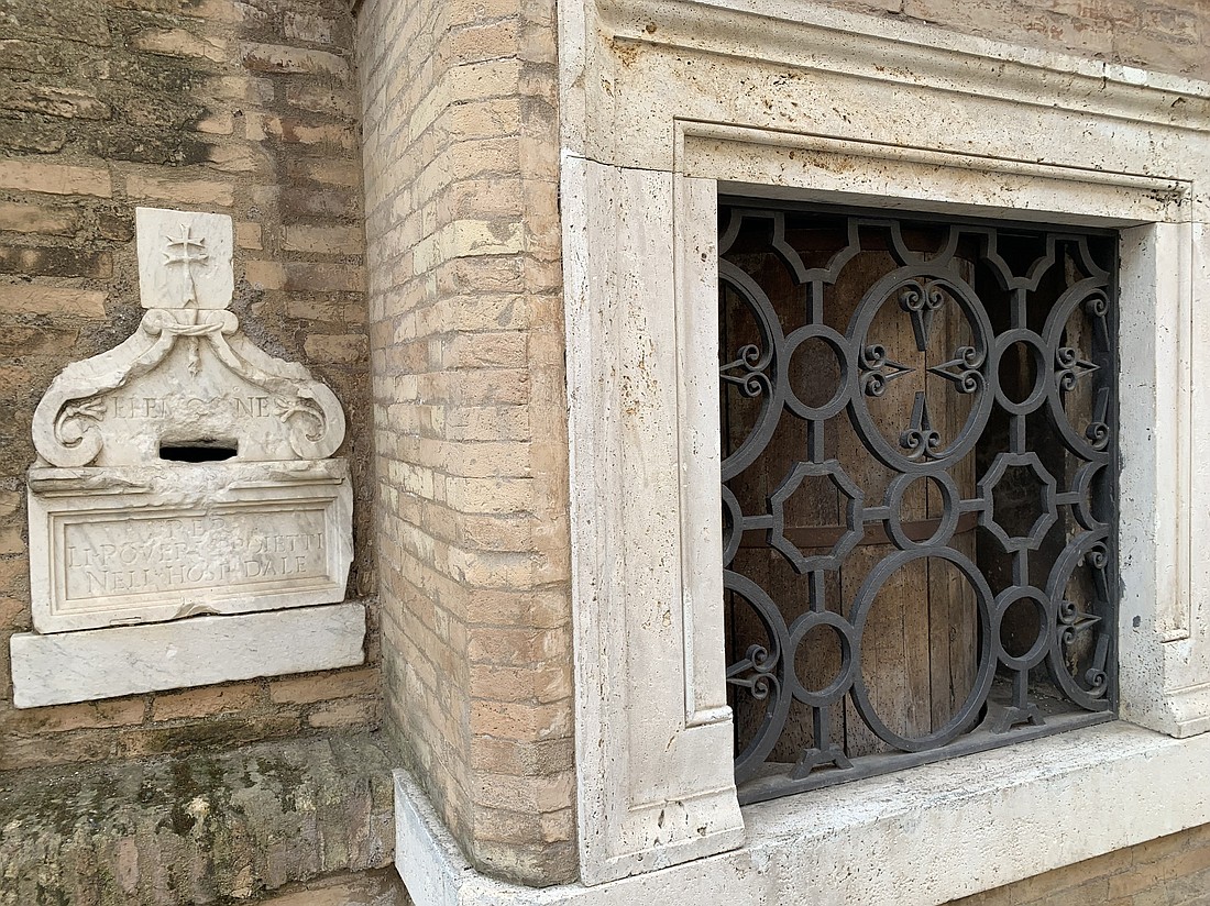 A slot for leaving alms for poor patients is seen next to a medieval foundling wheel, where people could leave abandoned newborns, at an entrance to Rome's Hospital of the Holy Spirit in Sassia in this photo from May 20, 2024. (CNS photo/Cindy Wooden)..