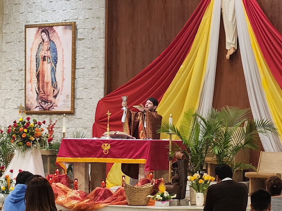 Divine Word Father Guilherme Andrino, pastor of Our Lady of Guadalupe Parish, Lakewood, elevates the Eucharist during Pentecost Mass May 19. Facebook photo