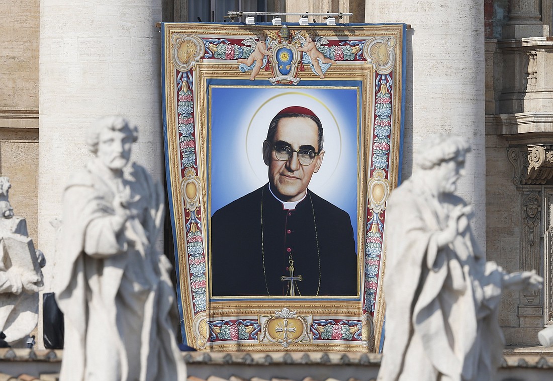 A banner of new St. Oscar Romero hangs from the facade of St. Peter's Basilica as Pope Francis celebrates the canonization Mass for seven new saints in St. Peter's Square at the Vatican Oct. 14, 2018. (CNS photo/Paul Haring)