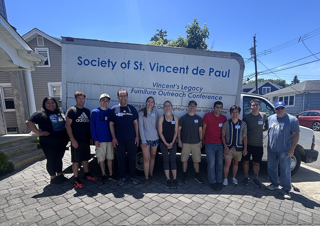 Young adults participating in the June 1 Service and Social pause for a photo with the St. Vincent de Paul delivery truck they loaded. Angelica Chicaiza photo