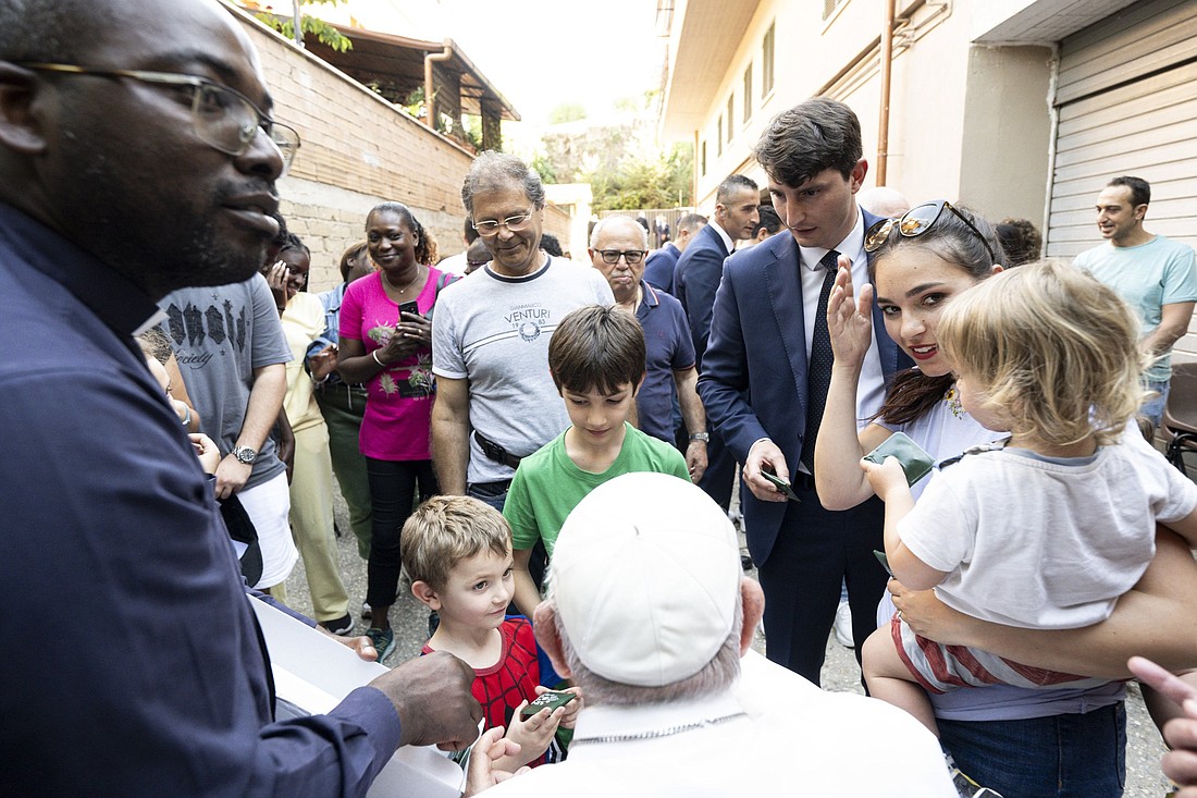 Pope Francis greets children outside the parking garages of a condominium on the outskirts of Rome where he met with families for an edition of his "School of Prayer" initiative June 6, 2024. (CNS photo/Vatican Media)