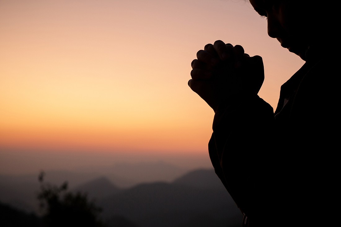 Silhouette of girl praying over beautiful sky background. Christian Religion concept background. fighting and victory for god