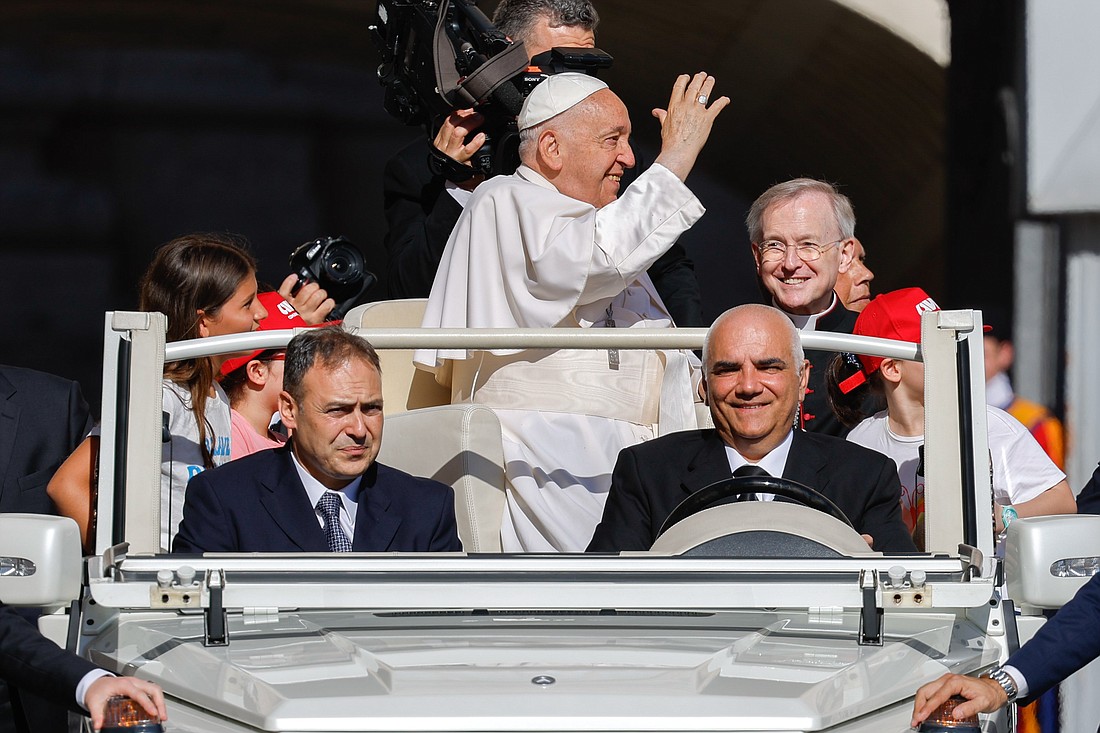 Pope Francis waves to visitors in St. Peter's Square as he rides the popemobile before his weekly general audience at the Vatican June 12, 2024. (CNS photo/Lola Gomez)