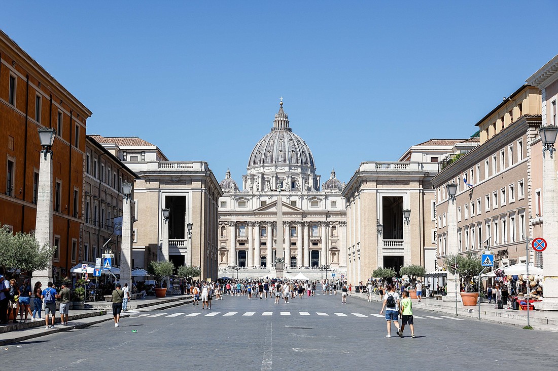 Pilgrims and tourists walk along the Via della Conciliazione toward St. Peter's Square and St. Peter's Basilica Aug. 15, 2023. The broad avenue is lined with many Vatican-owned buildings either used for Vatican offices and residences or rented out to earn money. (CNS photo/Lola Gomez)