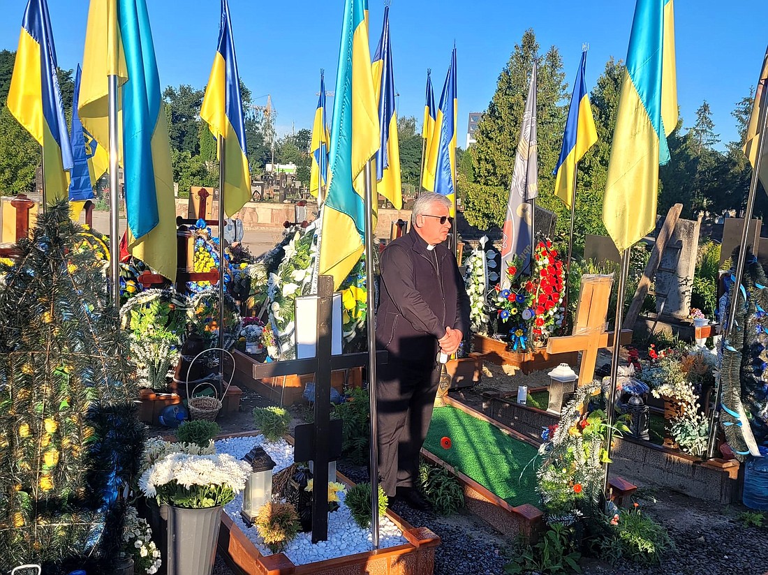Cardinal Konrad Krajewski, papal almoner, is seen in Ternopil, Ukraine, June 26, 2024, at the section of the local cemetery for Ukrainian soldeirs who died defending their country. Making his eighth trip to Ukraine, the cardinal donated an ambulance and medical supplies to a hospital in the country's Ternopil region. OSV News photo/courtesy Dicastery for the Service of Charity