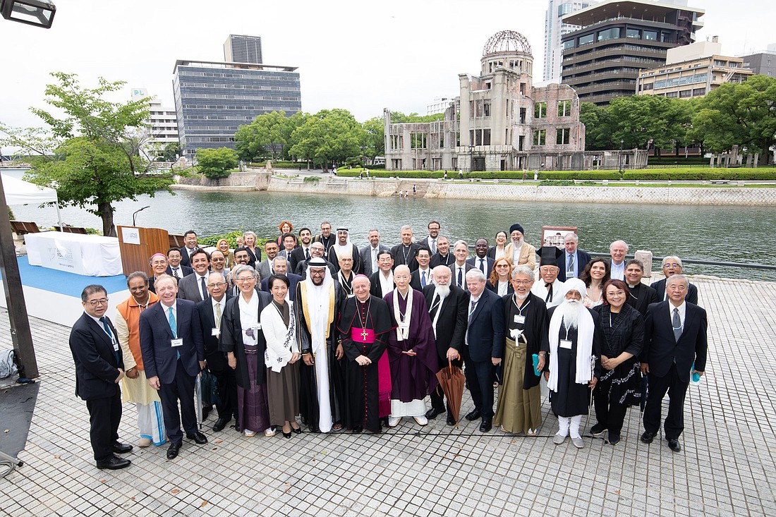 Participants of a conference on AI ethics, including several representatives of world religions, pose for a photo in Hiroshima, Japan, July 10, 2024. Standing front and center is Archbishop Vincenzo Paglia, president of the Pontifical Academy for Life. (CNS photo/Courtesy Holy See Press Office)