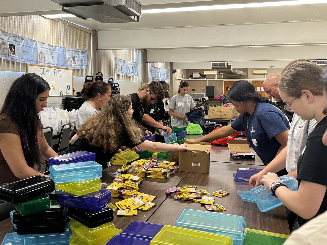 Teens assemble Hygiene kits and school supplies packs that will be distributed to students in need via Visitation Parish’s St. Vincent de Paul Society. M. Hartman photo