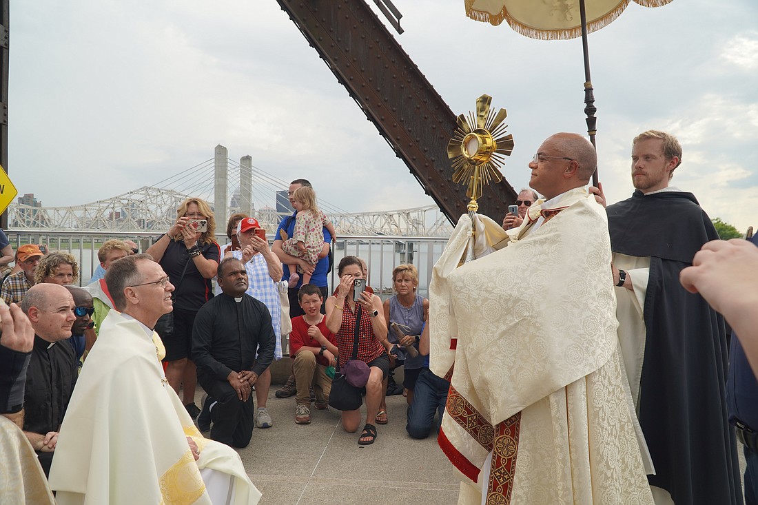 Archbishop Shelton J. Fabre of Louisville, Ky., transfers the monstrance to Archbishop Charles C. Thompson of Indianapolis during a Eucharistic procession across the Ohio River's Big Four Bridge July 9, 2024. The procession marked the end of the National Eucharistic Pilgrimage's route through the Archdiocese of Louisville. The pilgrimage was making its way next through southern Indiana and into Indianapolis. (OSV News photo/Marnie McAllister, The Record)