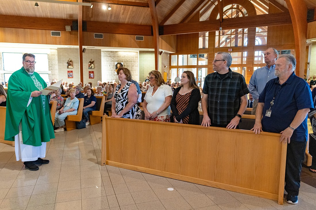 Father Kennedy, left, stands by members of his parish staff as well as parish and finance councils during the Mass of Installation. Hal Brown photo