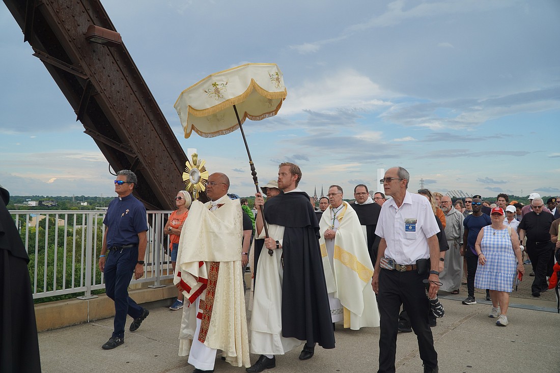 Archbishop Shelton J. Fabre of Louisville, Ky., carries the monstrance with the Blessed Sacrament in a procession across the Ohio River's Big Four Bridge July 9, 2024. The procession marked the end of the National Eucharistic Pilgrimage's route through the Archdiocese of Louisville. (OSV News photo/Marnie McAllister, The Record)