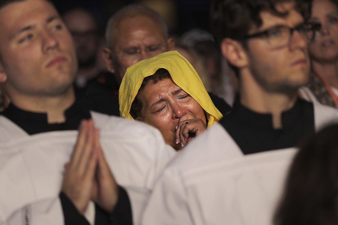 A pilgrim becomes emotional during Eucharistic adoration at the opening revival night July 17, 2024, of the National Eucharistic Congress at Lucas Oil Stadium in Indianapolis. (OSV News photo/Bob Roller)