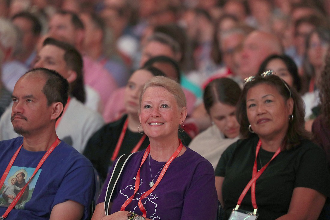 Pilgrims smile as New York Cardinal Timothy M. Dolan delivers the homily as he celebrates morning Mass at Lucas Oil Stadium July 18, 2024, during the National Eucharistic Congress  in Indianapolis. (OSV News photo/Bob Roller)