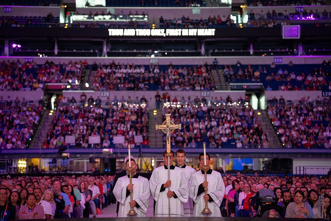 Altar servers carry candles and a crucifix during the procession of the gifts during Mass July 19, 2024, at Lucas Oil Stadium in Indianapolis during the National Eucharistic Congress. (OSV News photo/Scott Warden, courtesy Today's Catholic, Diocese of Fort Wayne-South Bend)