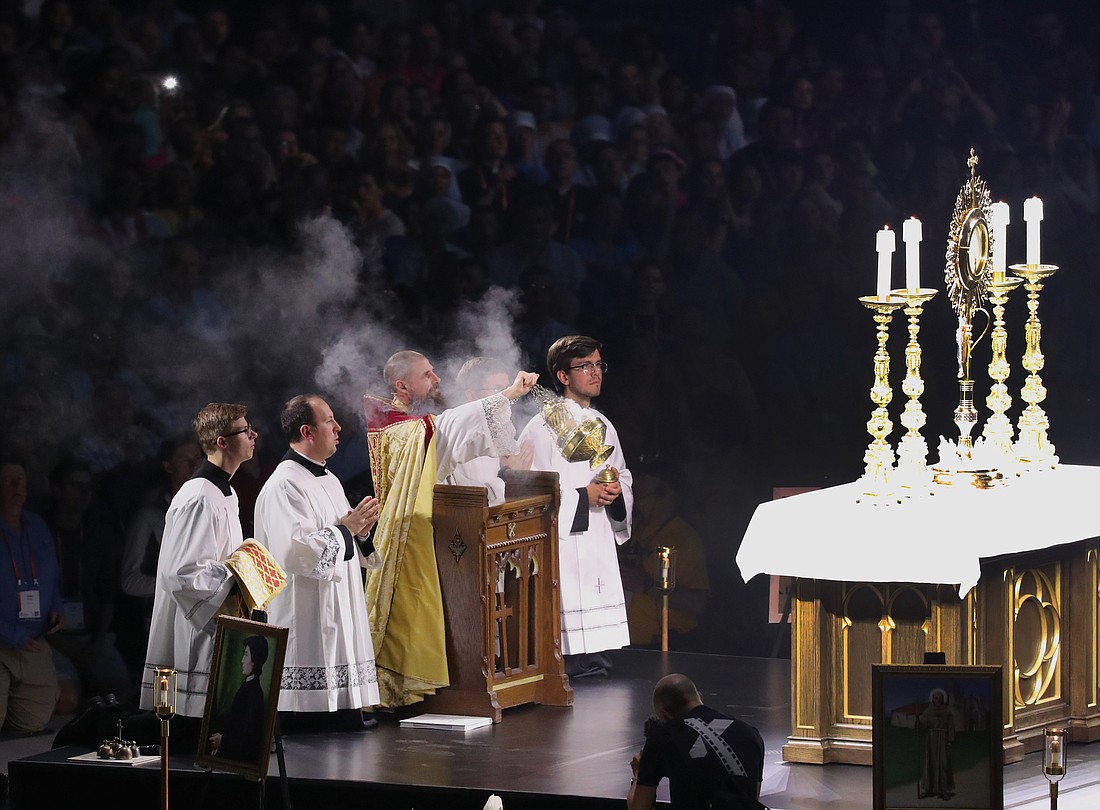 Father Boniface Hicks, a Benedictine monk of St. Vincent Archabbey in Latrobe, Pa., swings a censer in front of the monstrance during Eucharistic adoration July 19, 2024, at the third revival night of the National Eucharistic Congress at Lucas Oil Stadium in Indianapolis. (OSV News photo/Bob Roller)