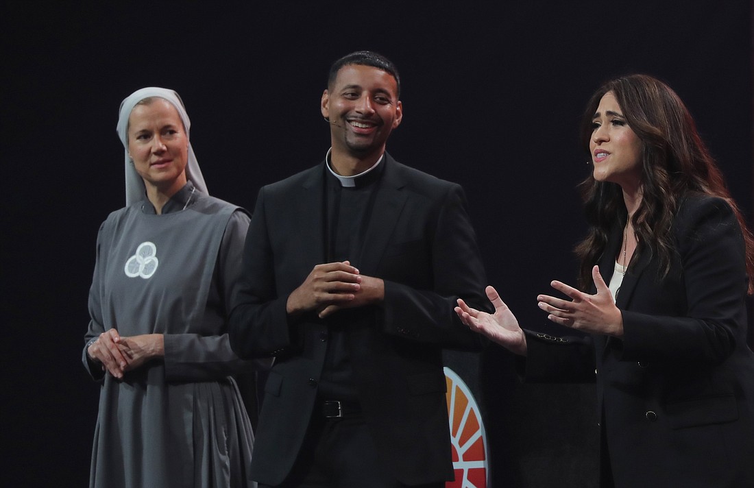 Sister Miriam James Heidland, a member of the Society of Our Lady of the Most Holy Trinity, Father Josh Johnson, director of vocations for the Diocese of Baton Rouge, La., and host of the podcast "Ask Father Josh," and Montse Alvarado, president and chief operating officer of EWTN News, react during the July 20, 2024, revival night of the National Eucharistic Congress at Lucas Oil Stadium in Indianapolis. (OSV News photo/Bob Roller)