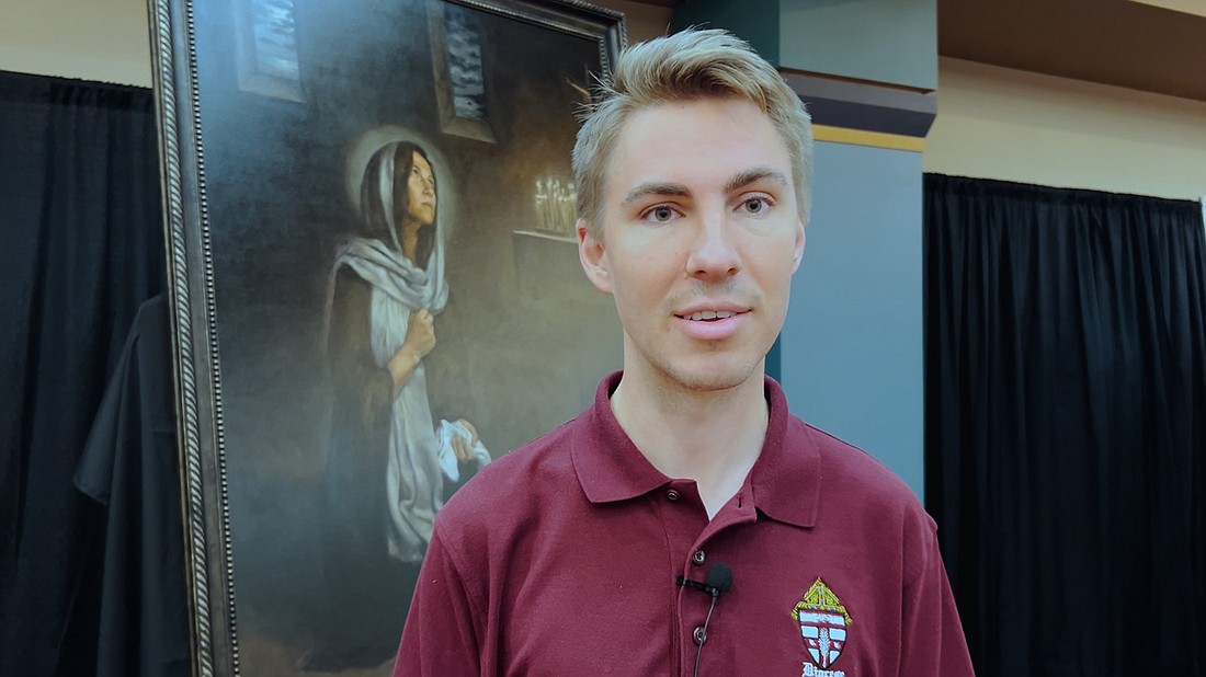 Seminarian Hunter Dickens from the Diocese of Owensboro, Ky., is seen July 18, 2024, standing in front of an image of St. Monica that was displayed along with other sacred art at the 10th National Eucharistic Congress in Indianapolis, (OSV News photo/Gina Christian)