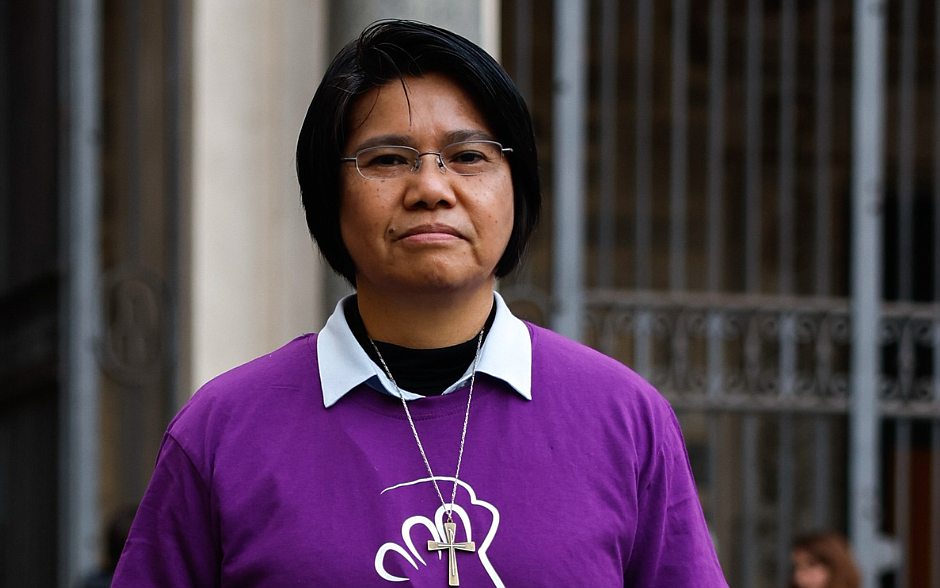 Caption: La hermana Maryknoll Abby Avelino posa para una foto sosteniendo un cartel en el que se lee “Esperanza” en la céntrica plaza Santa María in Trastevere de Roma el 6 de febrero de 2024. La hermana Avelino es la coordinadora internacional de Talitha Kum, una red internacional de religiosas que trabajan contra la trata de seres humanos. (Foto CNS/Lola Gomez)