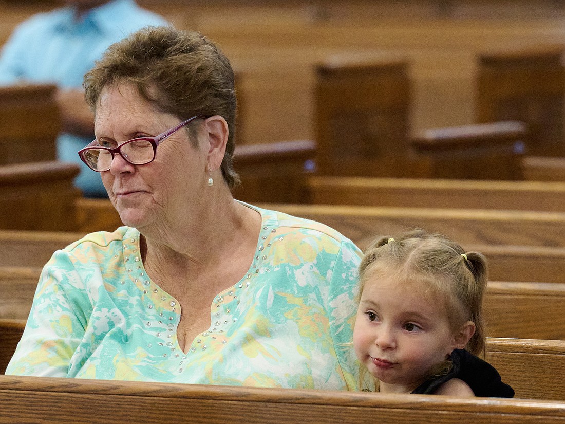 Margaret Keephart and her three-year-old granddaughter, Paige, attend the July 26 Mass for the Feast of Sts. Anne and Joachim in St. Anthony Church, Hamilton. Mike Ehrmann photo