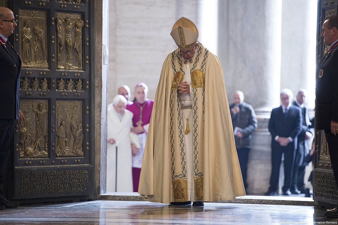 Pope Francis prays after walking through the Holy Door to inaugurate the Jubilee Year of Mercy in St. Peter's Basilica at the Vatican in this Dec. 8, 2015, file photo. In the background at left is retired Pope Benedict XVI, who walked through the Holy Door after Pope Francis. The pope has approved the theme, "Pilgrims of Hope," to be the motto for the Holy Year 2025. (CNS photo/Vatican Media)