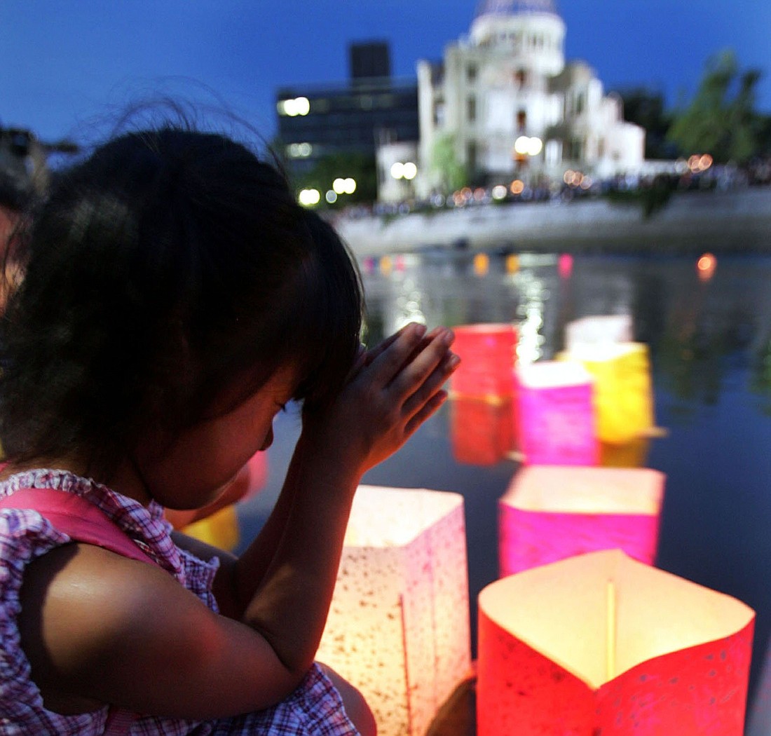 A girl prays after releasing a paper lantern on the Motoyasu River facing the gutted Atomic Bomb Dome in Hiroshima, Japan, Aug 6, 2020, the 75th anniversary of the United States dropping the atomic bomb on Hiroshima. Several U.S. bishops are undertaking a pilgrimage of peace to Hiroshima and Nagasaki, to advocate for nuclear disarmament. (OSV News photo/Yuriko Nakao, Reuters)