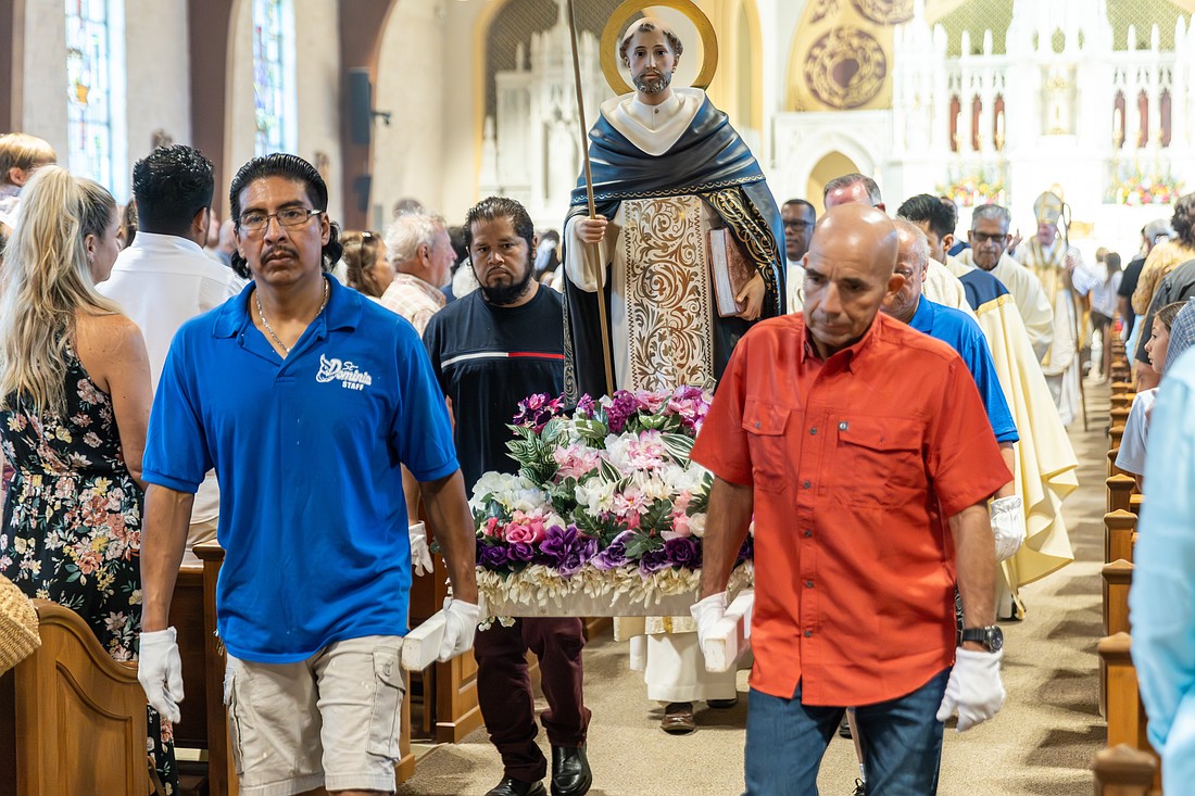 Parishioners carry the statue of St. Dominic from the church to where the outdoor procession would begin. Hal Brown photos.