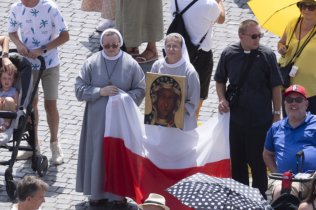 Two women religious and a priest holding an image of Mary and the Polish flag stand in St. Peter's Square at the Vatican as they joint Pope Francis for the recitation of the Angelus prayer Aug. 15, 2024, the feast of the Assumption of Mary. (CNS photo/Vatican Media)