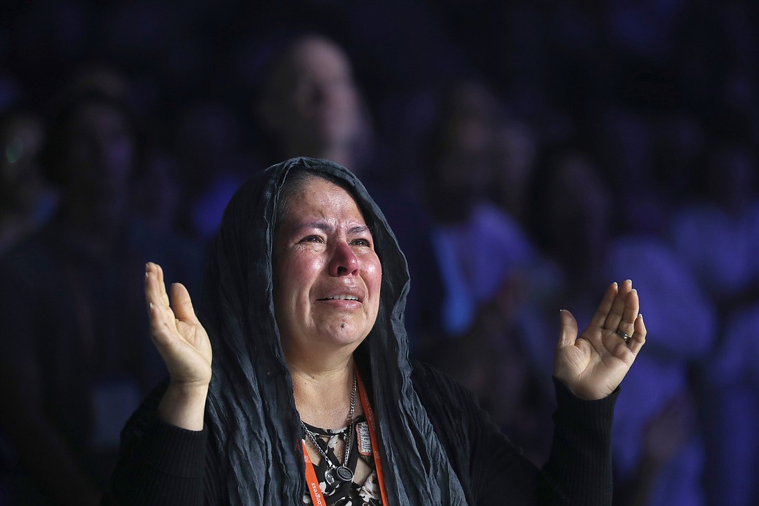 A pilgrim becomes emotional during Eucharistic adoration at the opening revival night July 17, 2024, of the National Eucharistic Congress at Lucas Oil Stadium in Indianapolis. (OSV News photo/Bob Roller)