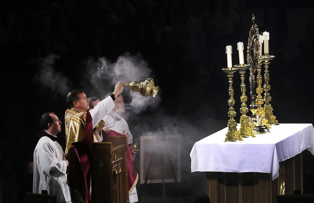 Bishop David L. Toups of Beaumont, Texas, swings a censer in front of the monstrance during Eucharistic adoration July 20, 2024, at the final revival night of the National Eucharistic Congress at Lucas Oil Stadium in Indianapolis. (OSV News photo/Bob Roller)