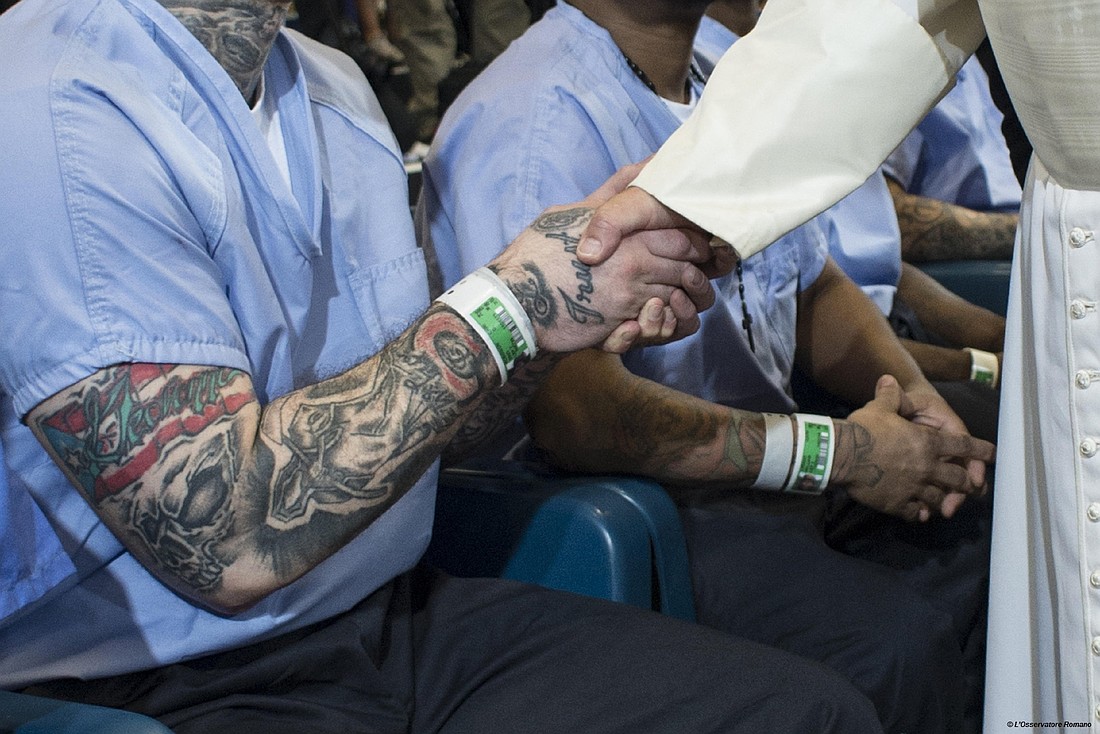 Pope Francis shakes hands with an inmate bearing a tattoo at the Curran-Fromhold Correctional Facility in Philadelphia Sept. 27, 2015. (CNS photo/L'Osservatore Romano)