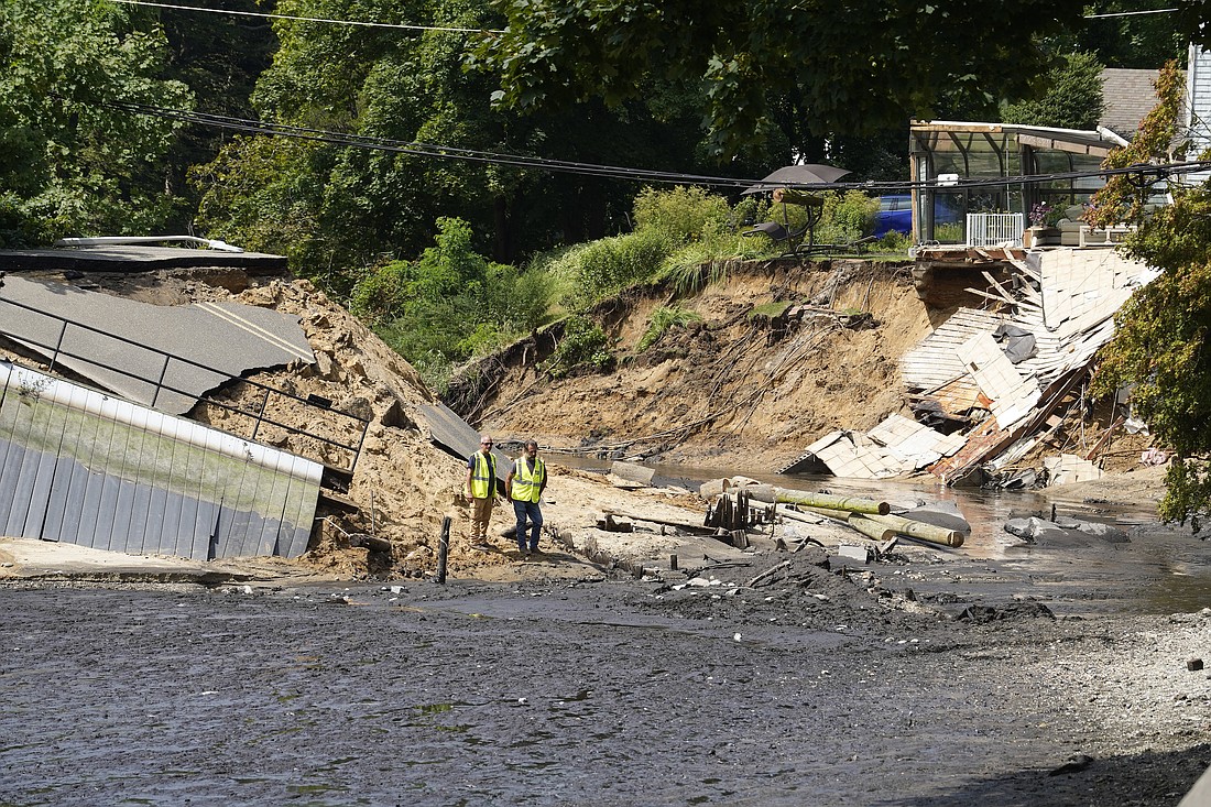 Workers inspect the remnants of Harbor Road in Stony Brook, N.Y., Aug. 19, 2024, after it collapsed earlier in the day when torrential rain caused a dam beneath the road to burst. The storm unleashed flash floods in parts of Long Island, N.Y., and southwestern Connecticut, where two women were found dead after they were swept away from their vehicles. (OSV News photo/Gregory A. Shemitz)