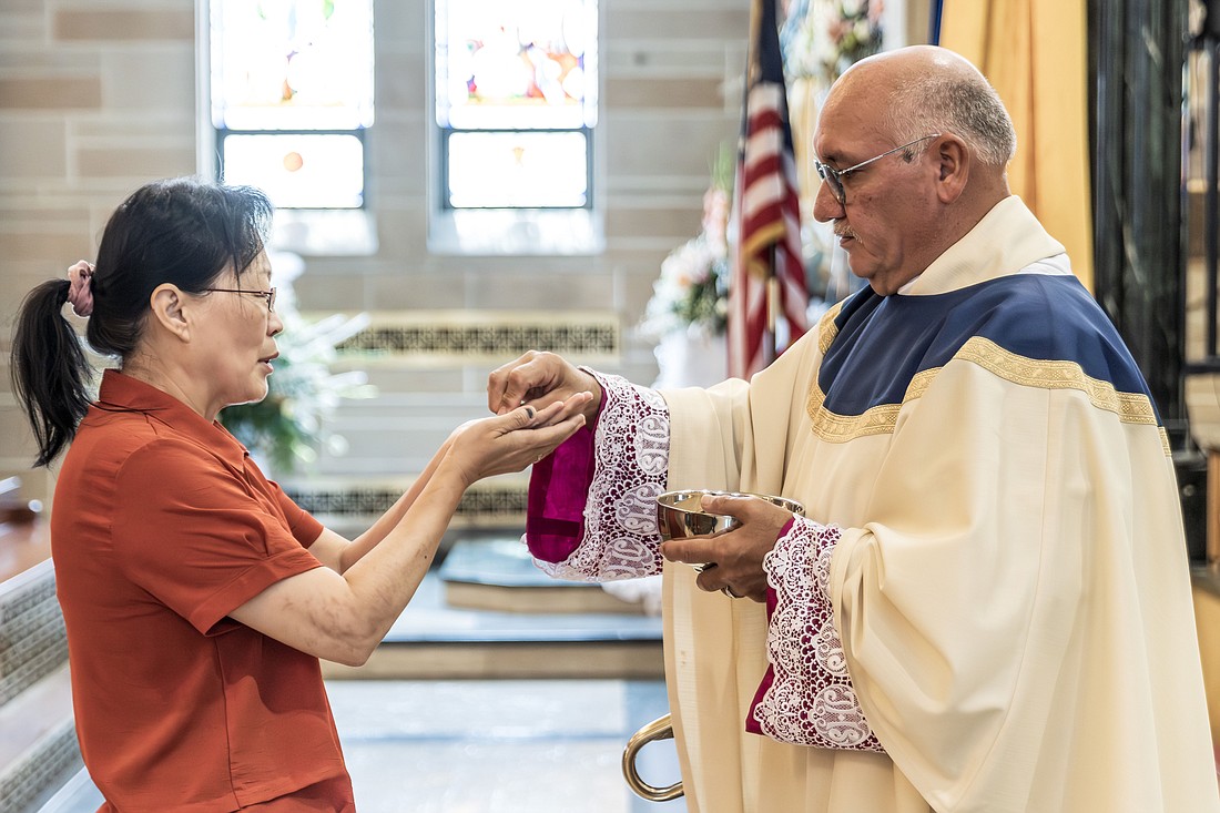 Msgr. Joseph Roldan, rector of St. Mary of the Assumption Cathedral, Trenton, administers the Eucharist during Mass on the Solemnity of the Assumption of the Blessed Virgin Mary, Aug. 15. For his Gospel reflection for Aug. 25, Father Garry Koch continues to speak on the Body and Blood of Jesus as being necessary for achieving Eternal Life. Hal Brown photo