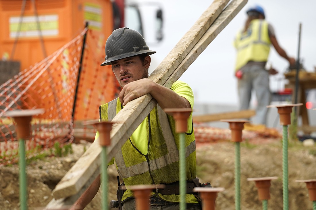 A worker carries lumber at a highway construction site in Stony Brook, N.Y., Aug. 30, 2022. (OSV News photo/CNS file, Gregory A. Shemitz)