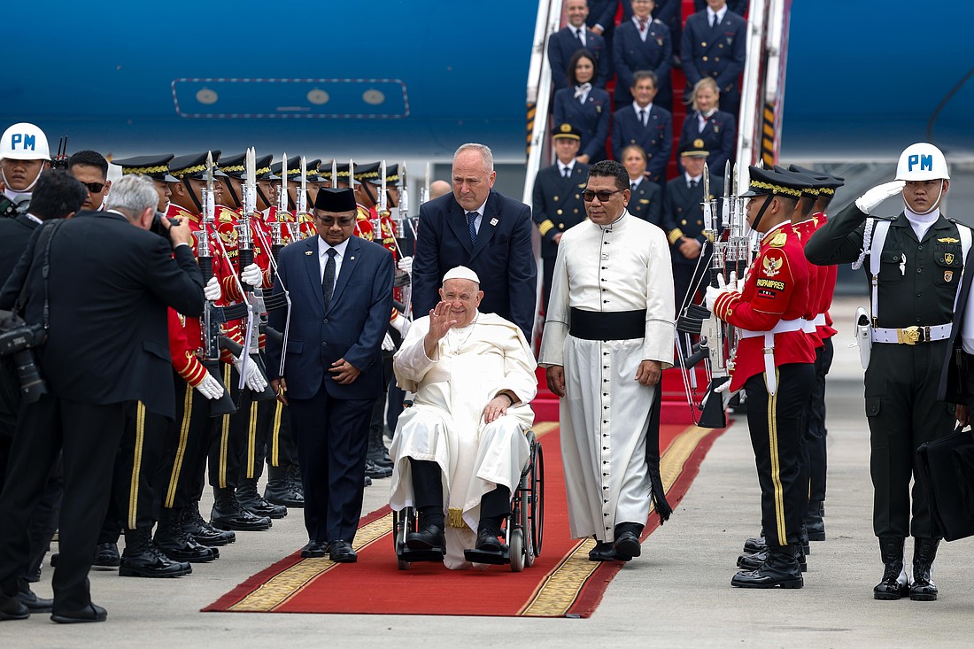 Pope Francis greets the crowd as he arrives at Soekarno-Hatta International Airport in Jakarta, Indonesia, Sept. 3, 2024. The Pope plans a four-day stay in Indonesia to visit the country's Catholic community, meet government and civic officials and promote interreligious dialogue. CNS photo/Lola Gomez