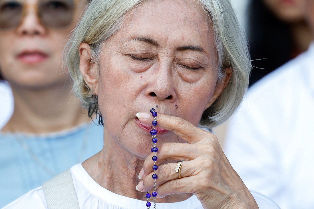 A woman prays as she awaits Mass with Pope Francis at Gelora Bung Karno Stadium in Jakarta, Indonesia, Sept. 5, 2024. (CNS photo/Lola Gomez)