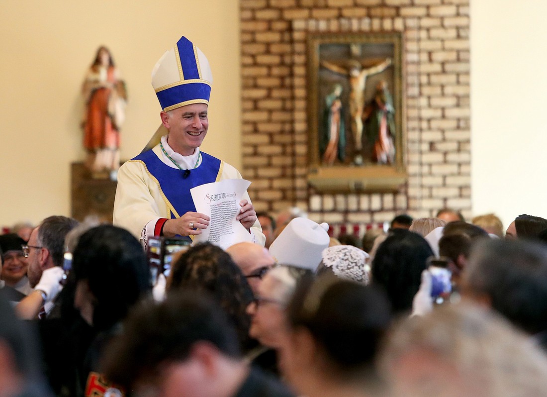 Coadjutor Bishop Joseph Williams shows the papal bull to all those who attended the Mass of Welcome on Sept. 10 at Saint Agnes Church, Blackwood. (Photo by Lori M. Nichols)