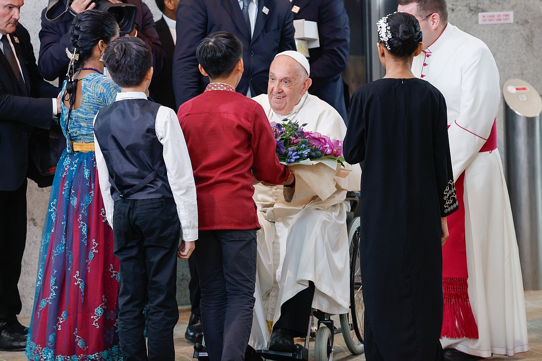 Pope Francis receives a bouquet of flowers from a group of children as he arrives Sept. 11, 2024, in Singapore, the last stop on his four-nation visit to Asia and the Pacific. (CNS photo/Lola Gomez)