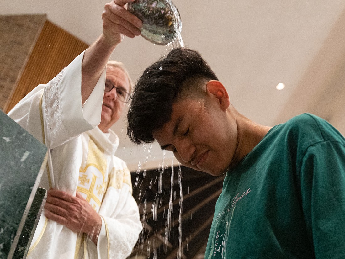 Father Scott Shaffer, pastor of St. Joseph Parish, Toms River, baptizes an elect in this Monitor file photo. Changes are underway in the formation process for newcomers to the Catholic faith. File photo